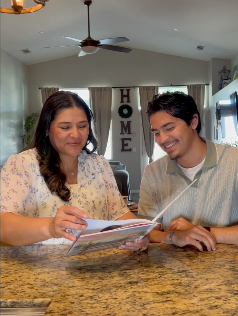 A smiling mother holding her personalized book, Mom, This is Our Story